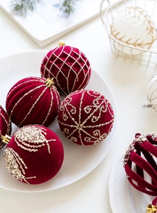 Gros plan sur des boules de Noël de 8cm en velours bordeaux avec paillettes dorées