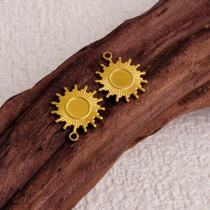 Polished 304 stainless steel sunburst pendant charms in gold finish on wood