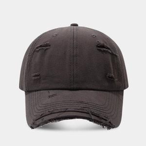 Close-up of distressed charcoal cotton baseball cap with ripped details and raw edges