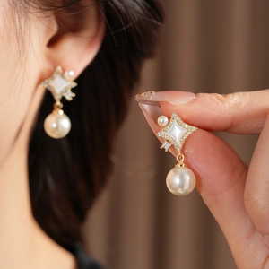 Détails des boucles d'oreilles étoile à quatre branches, nacre, zircone et perles