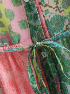 Gros plan d'une robe bohème avec boutons en coquillage et détails en fils métalliques dorés
