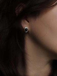 Elegant 925 sterling silver stud earrings featuring oval black agate stones on model