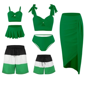 Flat lay of emerald green family swimwear set featuring bikinis and beach shorts