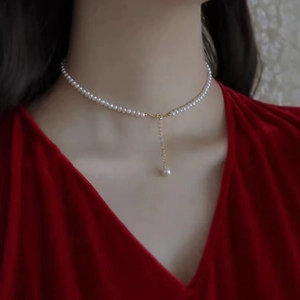 Detailed close-up of a s925 silver necklace with white pearls and gold pendant on a neck