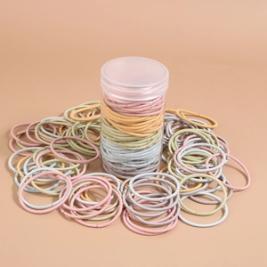 Dettaglio di elastici per capelli multicolori in un barattolo cilindrico trasparente