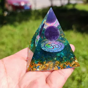 Orgone energy pyramid with purple crystal ball, Om symbol and green stone in resin