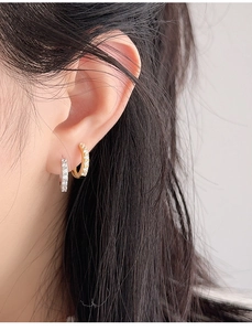 Close-up of gold and silver S925 sterling silver hoop earrings with sparkling pavé cubic zirconia