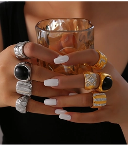 Detail of model wearing geometric gold and silver rings with black agate and diamonds