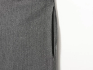 Macro shot of side seam pocket detailing on grey tailored trousers for women