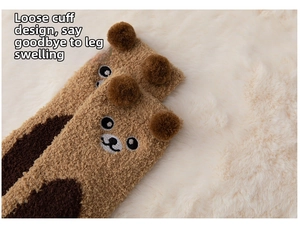 Close-up of fluffy coral fleece socks with cute bear embroidery and loose cuff detail