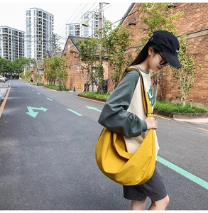 Casual yellow Oxford fabric half-moon bag worn by model in a street scene outdoors