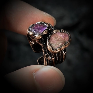 Macro detail of handmade vintage ring with purple and pink raw gemstones on bronze band