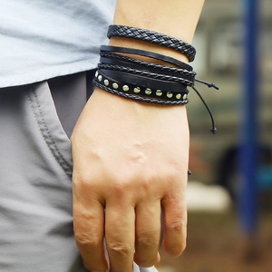 Close-up of black layered braided leather bracelets with metal studs on male wrist