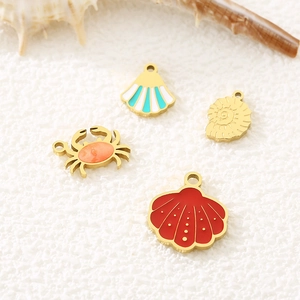 Marine themed stainless steel charms featuring colorful seashell, crab and conch pendants