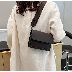 Detail view of deep coffee crossbody bag with adjustable wide fabric shoulder strap