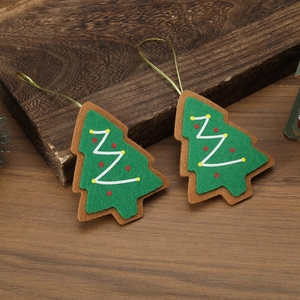 Detail of Christmas tree felt ornaments with green and brown layers on wood background
