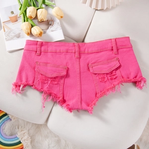 Dettaglio macro di pantaloncini di denim rosa con orli sfilacciati e tasche strappate