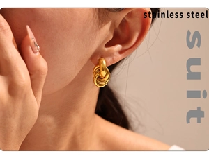 Macro detail of gold-plated stainless steel intertwined circle stud earrings on model