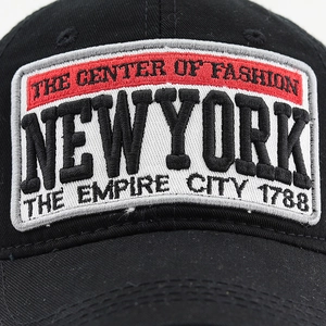 Détail macro de la broderie 3D New York sur le devant d'une casquette en coton noir