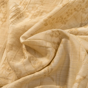 Macro detail of champagne gold jacquard fabric with floral patterns and ribbed textures
