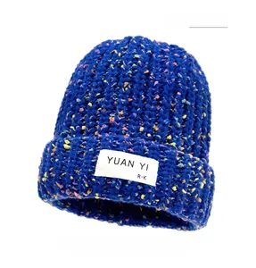 Close-up of navy blue confetti knit beanie with textured fabric and woven logo label