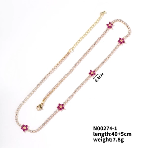 Detail view of gold flower necklace with white rhinestones and pink floral charms