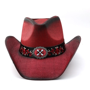Detailed close-up of red straw cowboy hat with floral embroidery and vintage metal buckle
