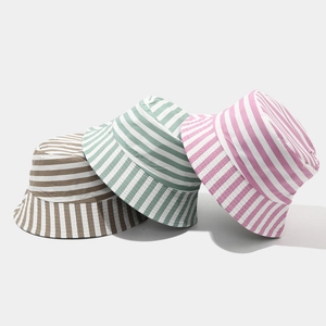 Close-up of three striped canvas bucket hats in brown, green, and pink color options