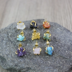Detailed close-up of 9-piece natural raw stone stud earrings set in gold claw settings