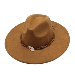 Close-up of brown suede wide-brim hat with bohemian beads and decorative woven rope