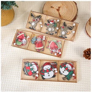 Detailed view of three boxed wooden Christmas pendants featuring Santa, reindeer, and snowman