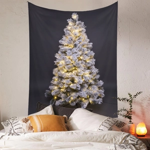 Arazzo natalizio con albero innevato e luci calde in un'accogliente camera da letto