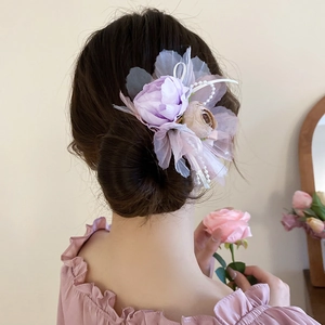 Detailansicht der Haarspange mit rosa Netzschleife, Seidenblüten und Perlenkette im Haar
