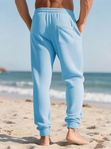 Detailed back view of light blue waffle knit joggers on a sunny beach setting