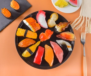 Vue de dessus de 15 modèles de sushi réalistes avec saumon et thon sur une assiette noire