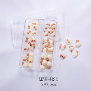 Detailed view of cream resin nail charms featuring bows and bears in a six-grid box