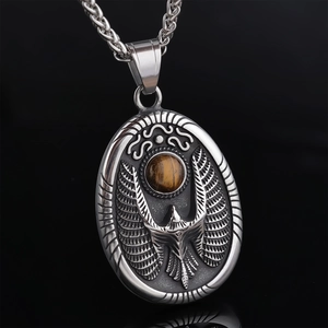 Macro shot of silver eagle relief pendant with round tiger eye stone and woven chain link