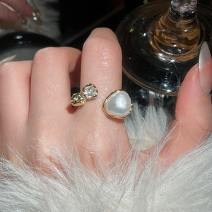 Macro detail of French vintage gold ring featuring a white pearl and sparkling zircon stones