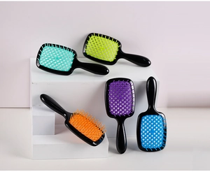 Five hollow grid hair brushes in vibrant colors displayed on a geometric platform