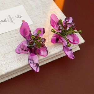 Macro detail of vintage floral earrings with translucent purple petals and beaded centers