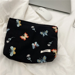 Embroidered butterfly makeup bag in black canvas with floral patterns and zipper closure