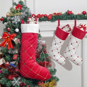 Calze di Natale rosse e bianche con paillettes appese al camino e all'albero decorato