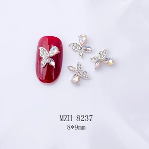 Détail du bijou d'ongles papillon 3D avec ailes irisées et base en métal argenté brillant