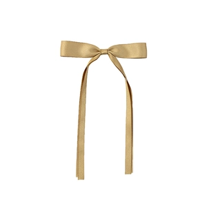 Close-up of golden satin ribbon bow hair clip with long streamers on white background