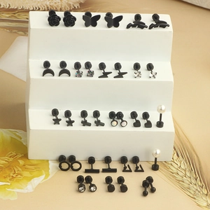 Detailed macro view of black stainless steel piercing stud earring set with various charms