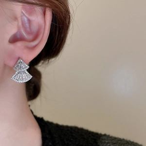 Close-up of model wearing silver triangle fan earrings with shimmering cubic zirconia