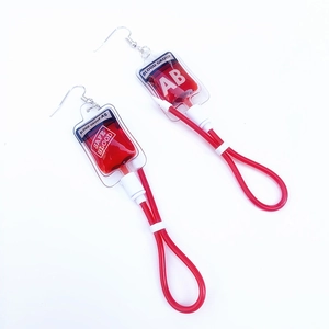 Detailed close-up of creative Harajuku blood bag earrings with AB blood group printing