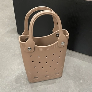 Close-up of khaki EVA tote bag showing breathable hole design and metal rivet details