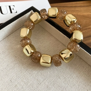Close-up of acrylic geometric beads bracelet with gold mirror and brown glitter beads