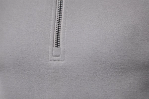 Close-up of a dark grey knit sweatshirt featuring a metallic half-zip stand collar